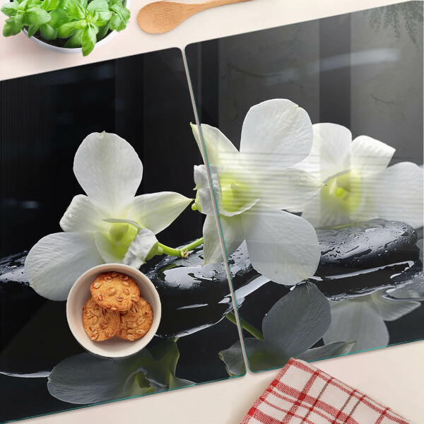 Glas-Schneidebrett mit Orchideenmotiv auf schwarzem Hintergrund