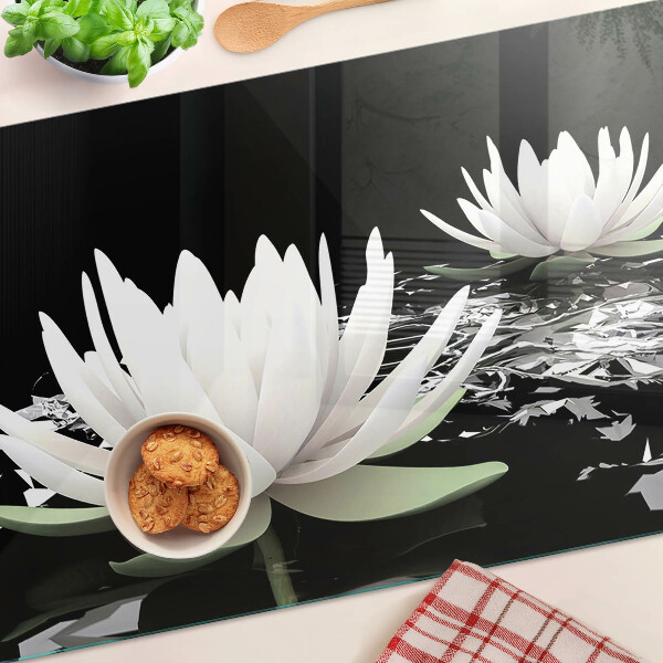 Schneidebrett aus Glas mit Seerosen auf schwarzem Hintergrund