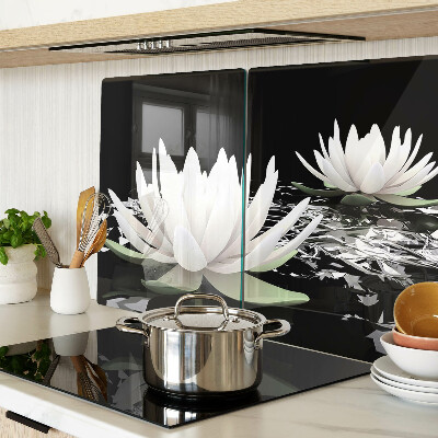 Schneidebrett aus Glas mit Seerosen auf schwarzem Hintergrund