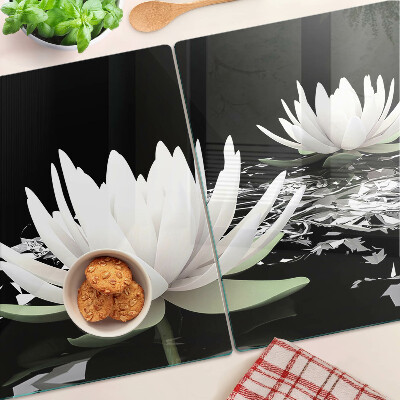 Schneidebrett aus Glas mit Seerosen auf schwarzem Hintergrund