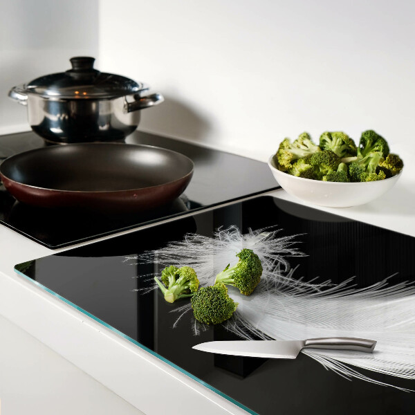 Schneidebrett glas Feder auf schwarzem Hintergrund