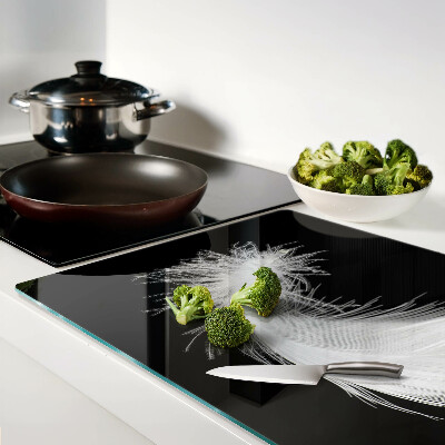 Schneidebrett Glas mit Motiv einer Feder auf schwarzem Hintergrund