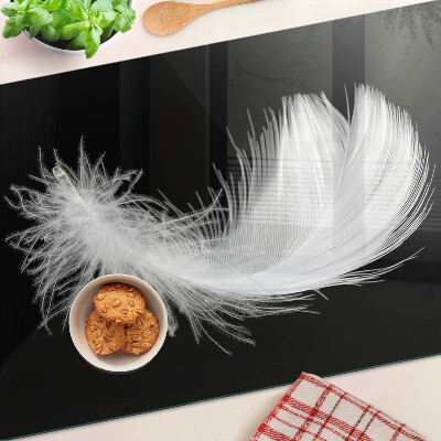 Schneidebrett glas Feder auf schwarzem Hintergrund