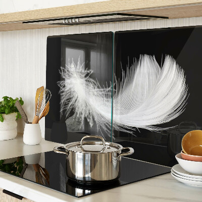 Schneidebrett Glas mit Motiv einer Feder auf schwarzem Hintergrund