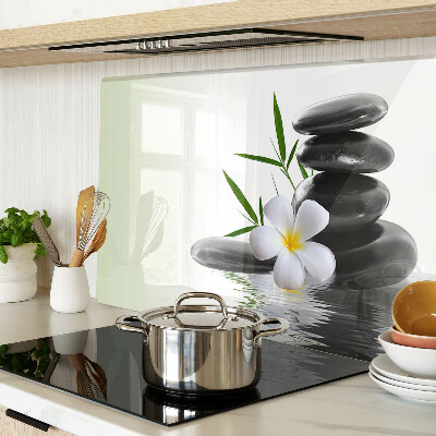 Schneidebrett mit Motiv aus Blumen und Kieselsteinen auf Wasser