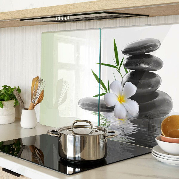 Schneidebrett mit Motiv aus Blumen und Kieselsteinen auf Wasser