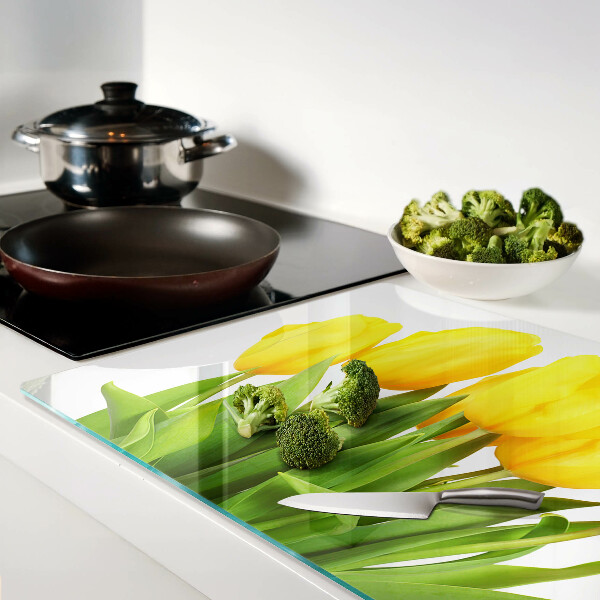 Schneidebrett mit gelben Tulpen vor grünem Hintergrund