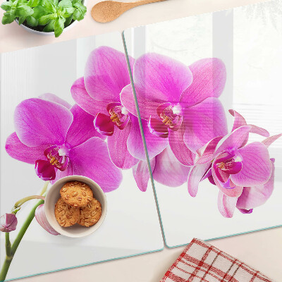 Glas-Schneidebrett mit Orchideen in Rosatönen
