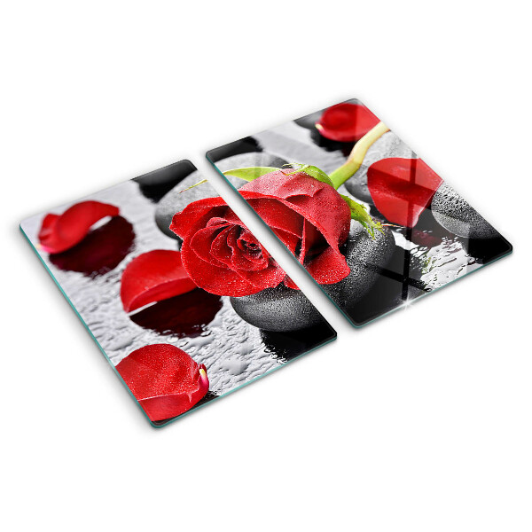 Glas schneidebrett Rose auf Steinen mit Wassertropfen