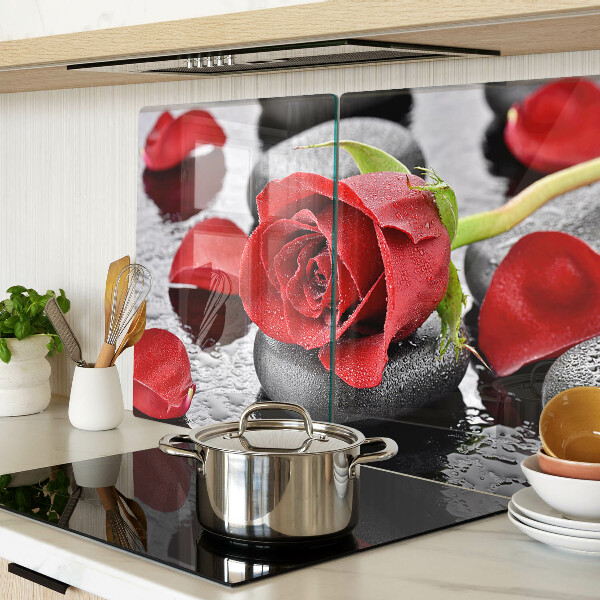 Glas schneidebrett Rose auf Steinen mit Wassertropfen