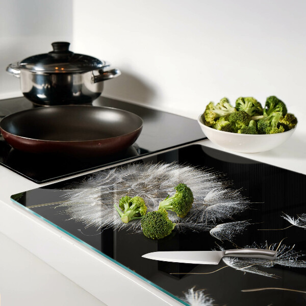 Schneidebrett glas Löwenzahn auf schwarzem Hintergrund