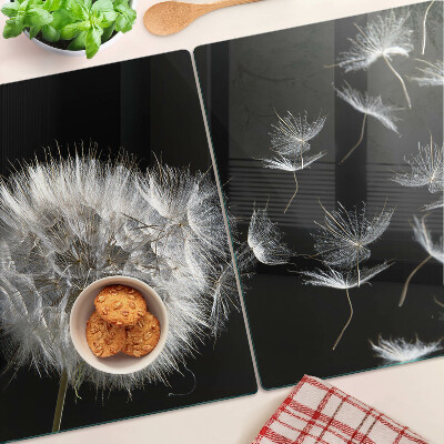 Schneidebrett glas Löwenzahn auf schwarzem Hintergrund