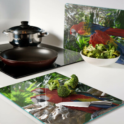 Glas-Schneidebrett mit Papageienmotiv in einer tropischen Umgebung