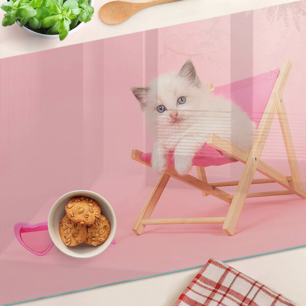 Schneidebrett Ein Kätzchen auf einem Liegestuhl vor rosa Hintergrund