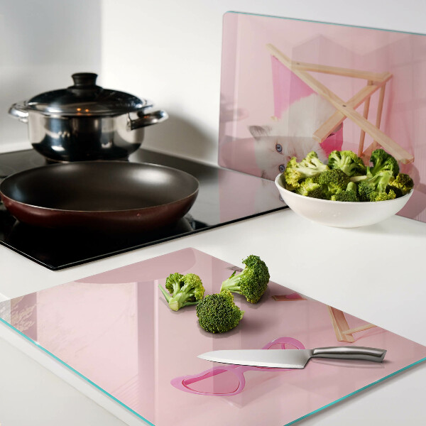 Schneidebrett mit Motiv eines Kätzchens auf einem Liegestuhl vor rosa Hintergrund