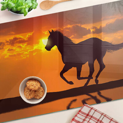 Schneidebrett Ein Pferd vor dem Hintergrund der untergehenden Sonne