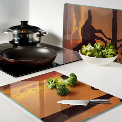 Schneidebrett mit Pferdemotiv vor untergehender Sonne