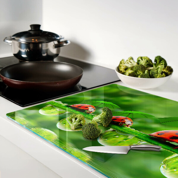 Schneidebrett Glas mit Marienkäfer-Motiv auf Blättern und Wassertropfen