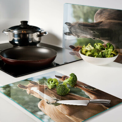 Glas-Schneidebrett mit Pferdemotiv vor Naturlandschaft