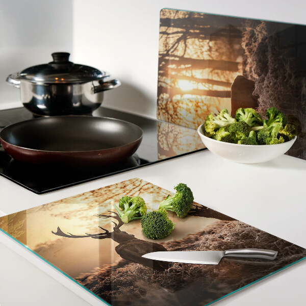 Schneidebrett mit Motiv von Hirschen im Wald bei Sonnenuntergang