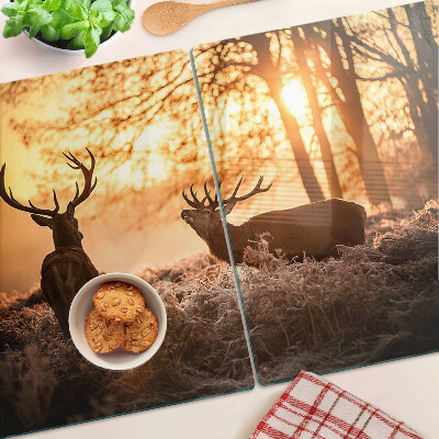 Schneidebrett mit Motiv von Hirschen im Wald bei Sonnenuntergang