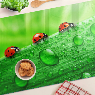 Schneidebrett mit einem Marienkäfer auf grünem Hintergrund