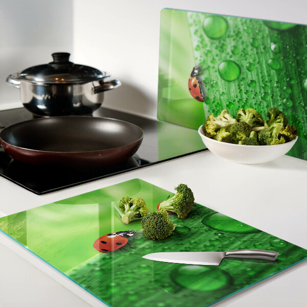 Schneidebrett mit einem Marienkäfer auf grünem Hintergrund