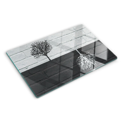 Schneidebrett Glas mit Motiv eines Baums vor einem Backsteinhintergrund