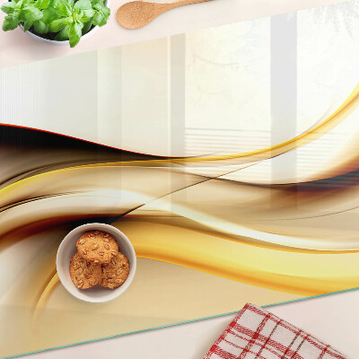 Schneidebrett Glas mit abstraktem Wellenmotiv in Goldtönen