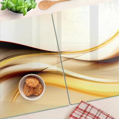 Schneidebrett Glas mit abstraktem Wellenmotiv in Goldtönen