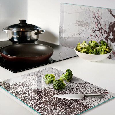 Glas-Schneidebrett mit einer Berglandschaft und blühenden Bäumen