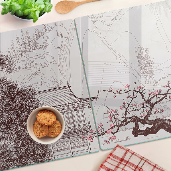 Glas-Schneidebrett mit einer Berglandschaft und blühenden Bäumen