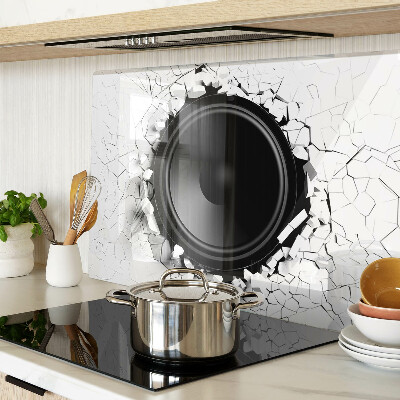 Schneidebrett mit Lautsprecher-Motiv vor einer zerbrochenen Wand