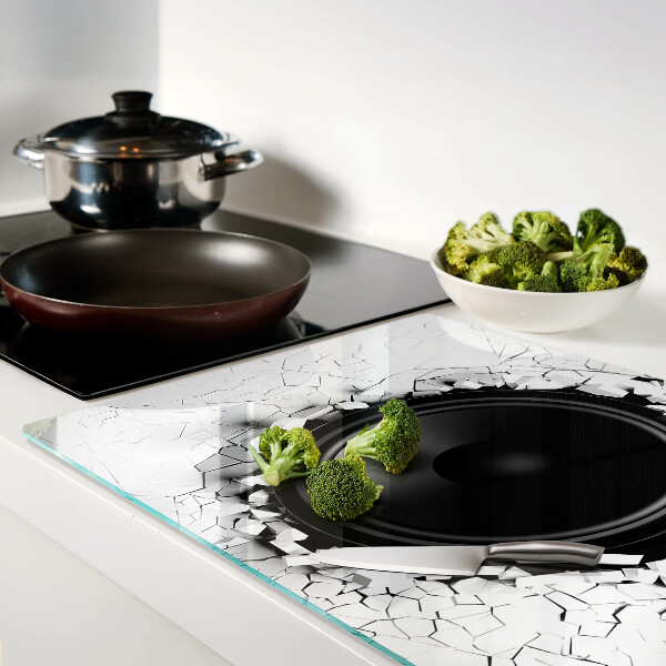 Schneidebrett mit Lautsprecher-Motiv vor einer zerbrochenen Wand