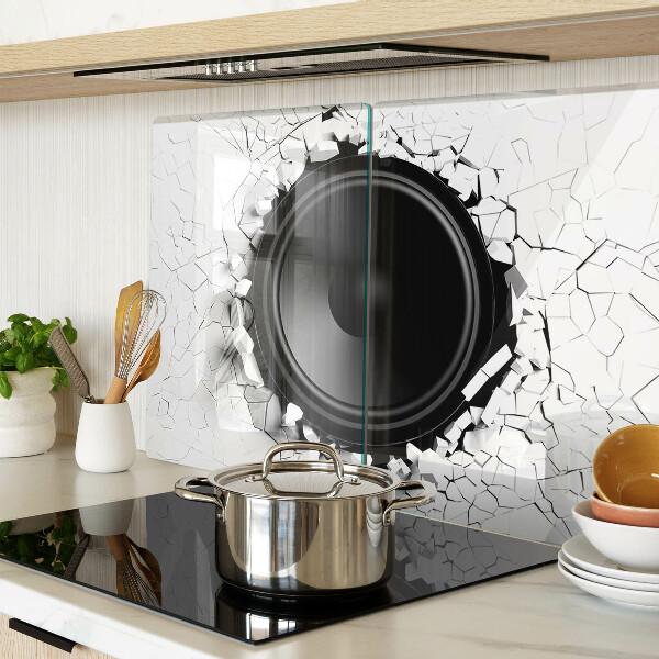 Schneidebrett mit Lautsprecher-Motiv vor einer zerbrochenen Wand