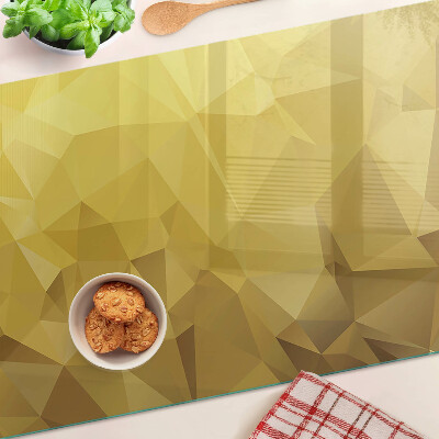 Glas-Schneidebrett mit geometrischem Muster in Goldtönen