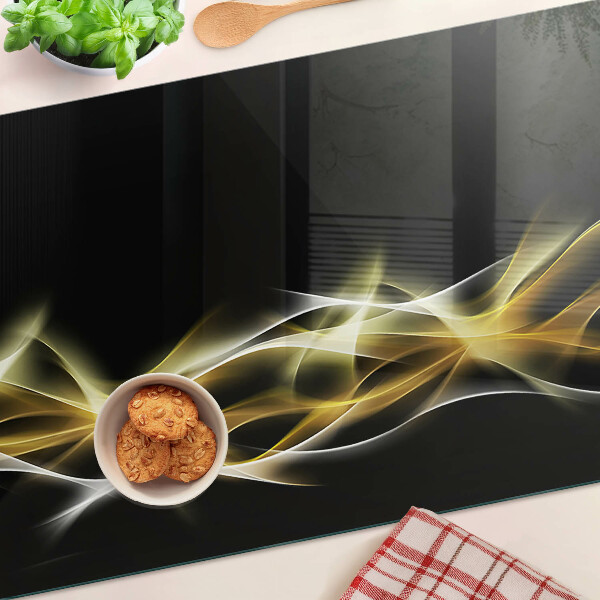 Glas-Schneidebrett mit einem goldfarbenen Lichtwellendekor