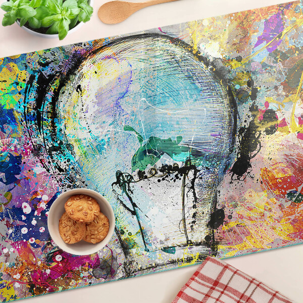 Schneidebrett mit Motiv einer Glühbirne auf farbigem Hintergrund