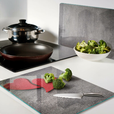 Schneidebrett mit einem Herzmotiv vor einem Fenster