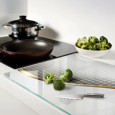 Schneidebrett Glas mit einem goldenen Wellenmotiv auf gepunktetem Hintergrund