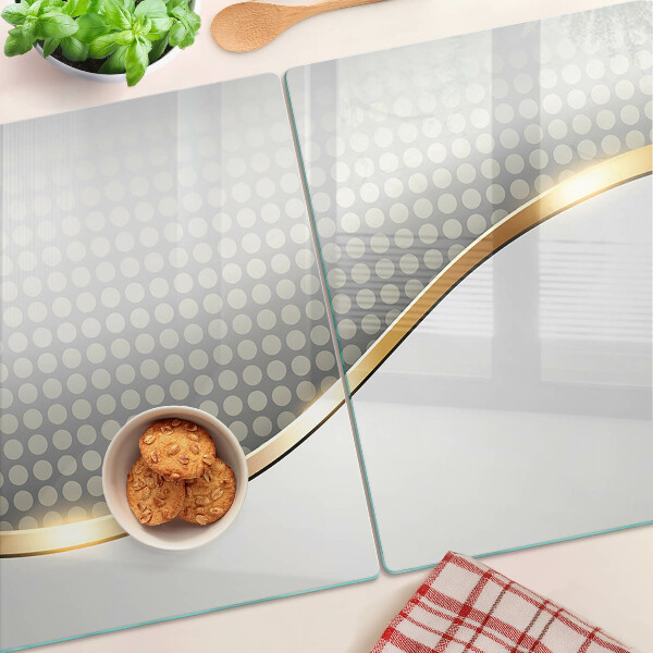 Schneidebrett Glas mit einem goldenen Wellenmotiv auf gepunktetem Hintergrund