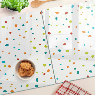 Glas-Schneidebrett mit bunten Punkten auf weißem Hintergrund