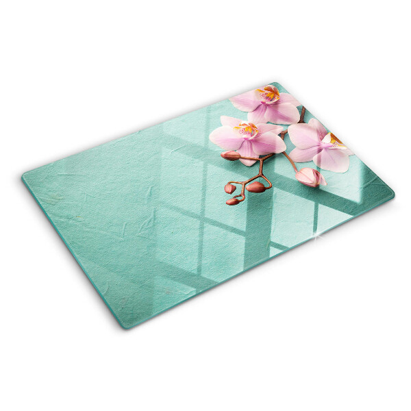 Glas Schneidebrett mit Orchideenmotiv auf blauem Hintergrund