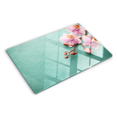 Glas Schneidebrett mit Orchideenmotiv auf blauem Hintergrund