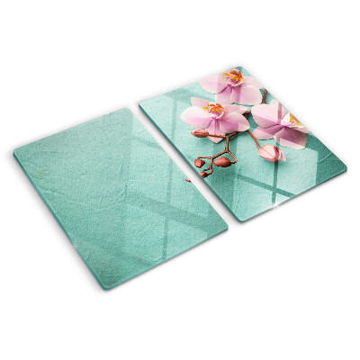 Glas Schneidebrett mit Orchideenmotiv auf blauem Hintergrund