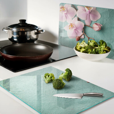 Glas schneidebrett Orchideen auf blauem Hintergrund