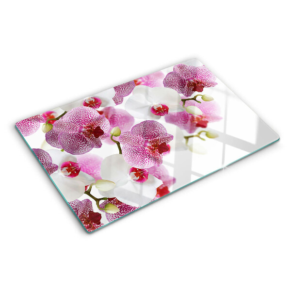 Glas-Schneidebrett mit Orchideen vor einem Fenster als Motiv
