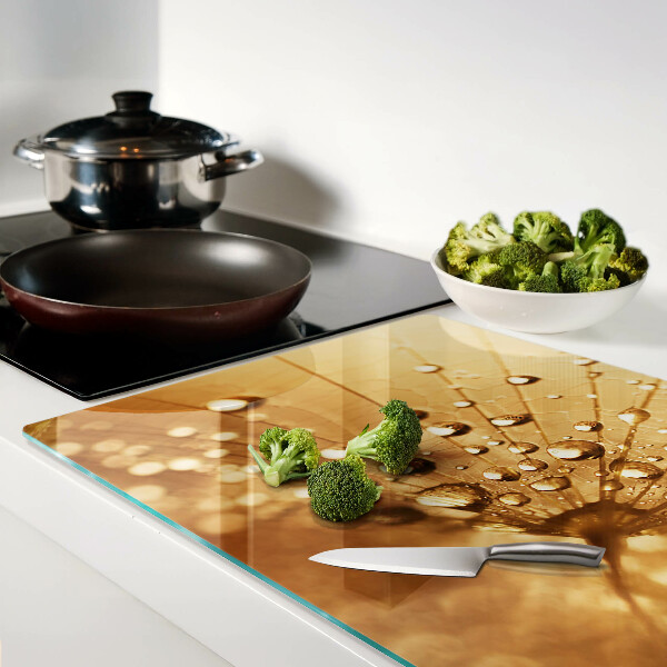 Glas schneidebrett mit Motiv von Wassertropfen auf einem Löwenzahn