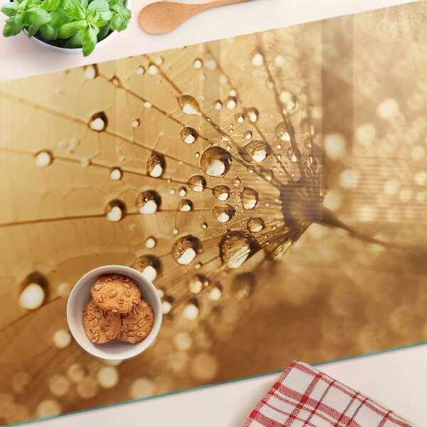 Glas schneidebrett Wassertropfen auf einem Löwenzahn