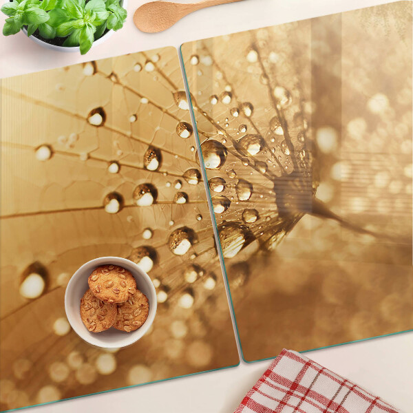 Glas schneidebrett mit Motiv von Wassertropfen auf einem Löwenzahn